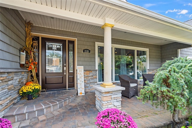 property entrance with stone siding and a porch