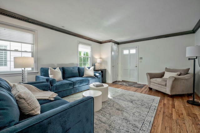 living room featuring baseboards, ornamental molding, and wood finished floors