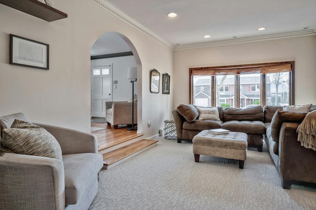 living room with baseboards, arched walkways, light colored carpet, crown molding, and recessed lighting