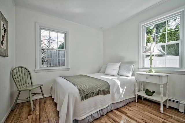 bedroom featuring crown molding, baseboards, and wood finished floors