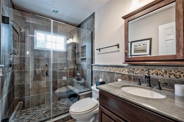 full bath featuring toilet, a shower stall, tile walls, and vanity