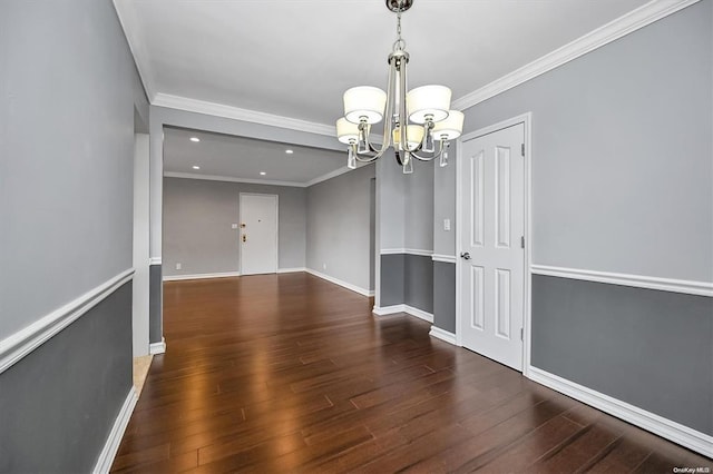 unfurnished room with ornamental molding, a notable chandelier, baseboards, and wood finished floors