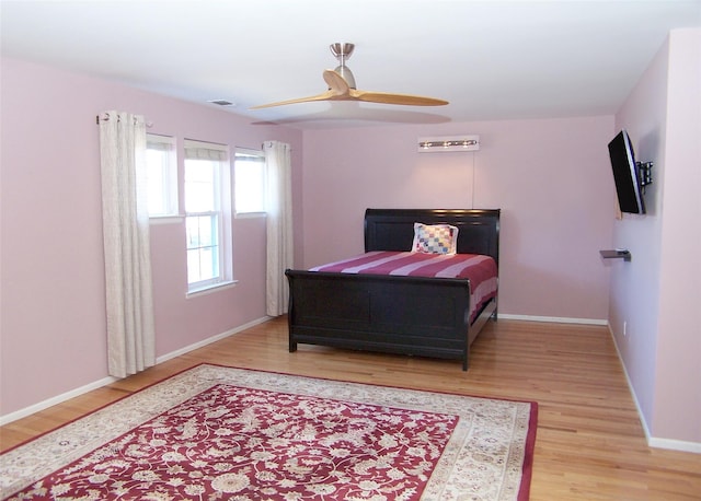 bedroom featuring baseboards, ceiling fan, visible vents, and light wood-style floors