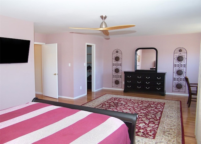 bedroom featuring a ceiling fan, baseboards, and wood finished floors