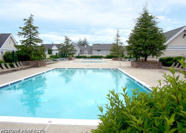 community pool featuring a residential view and a patio area