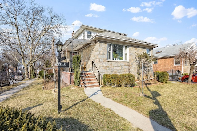 bungalow-style house with stone siding, a chimney, and a front yard