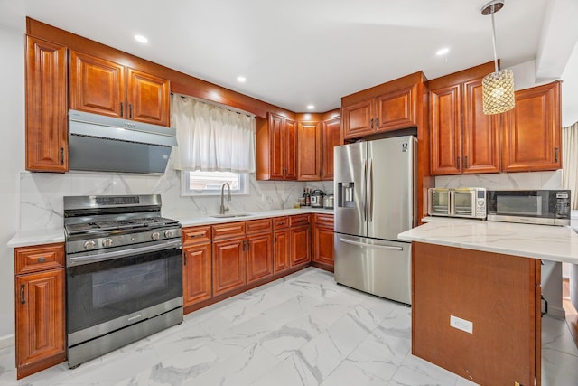 kitchen featuring marble finish floor, appliances with stainless steel finishes, a sink, and brown cabinets