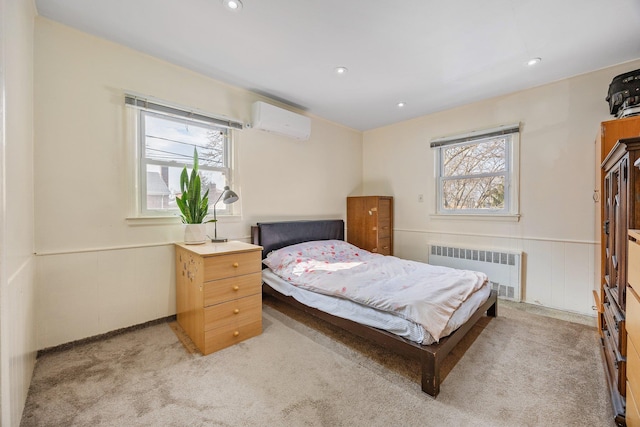 bedroom with recessed lighting, light colored carpet, a wall mounted AC, wainscoting, and radiator