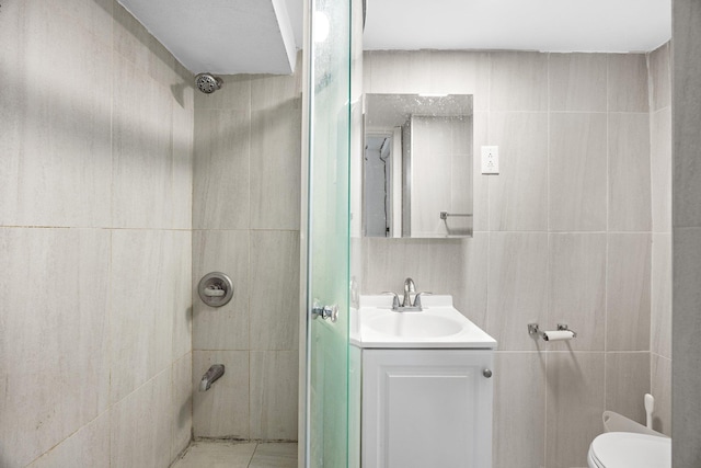 bathroom featuring toilet, walk in shower, tile walls, and vanity