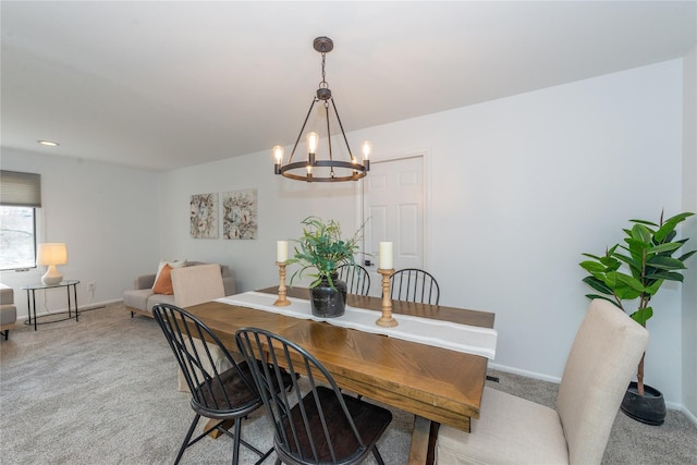 dining area featuring light colored carpet, baseboards, and an inviting chandelier