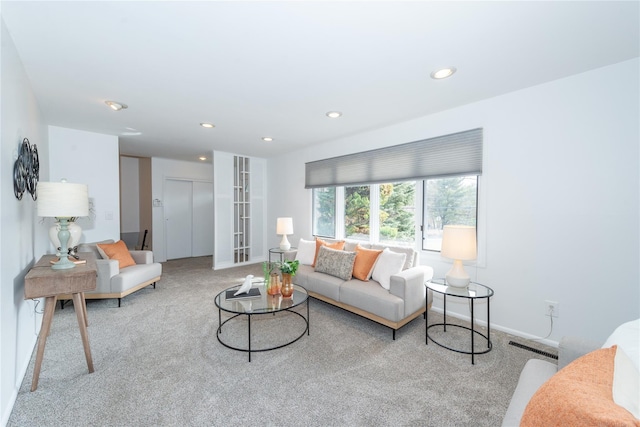 carpeted living room with baseboards, visible vents, and recessed lighting