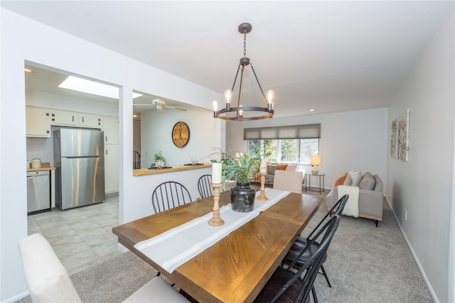 dining space with ceiling fan with notable chandelier and baseboards