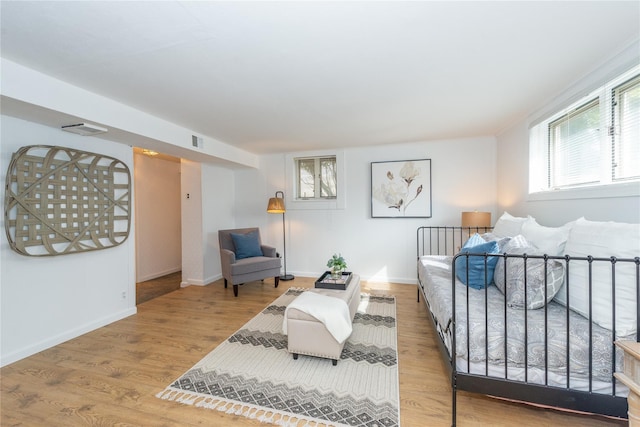 bedroom featuring wood finished floors, visible vents, and baseboards