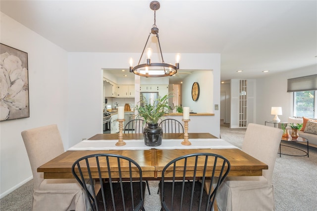 dining room with recessed lighting, baseboards, a notable chandelier, and light colored carpet