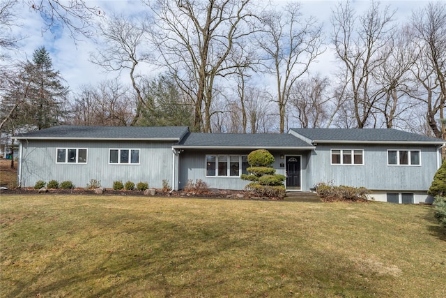 ranch-style home featuring a shingled roof and a front yard