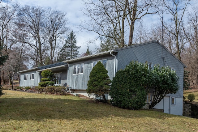 view of side of home with a yard