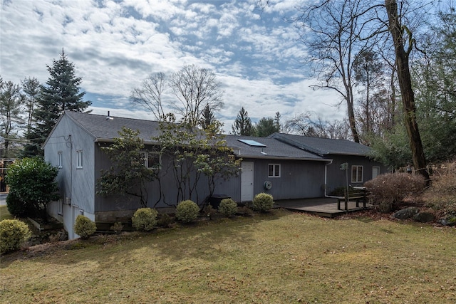 back of house with a deck and a yard