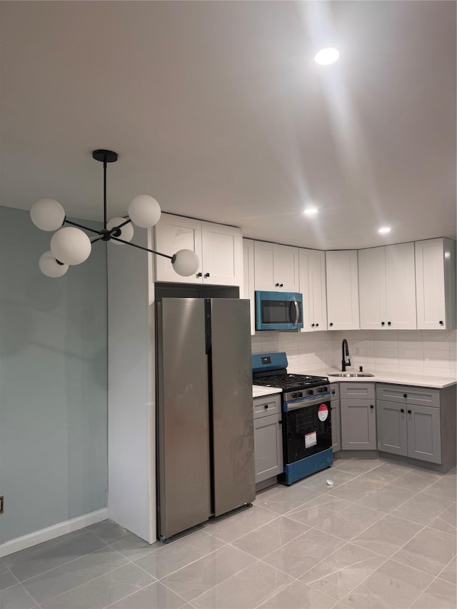 kitchen with tasteful backsplash, appliances with stainless steel finishes, gray cabinets, light countertops, and a sink