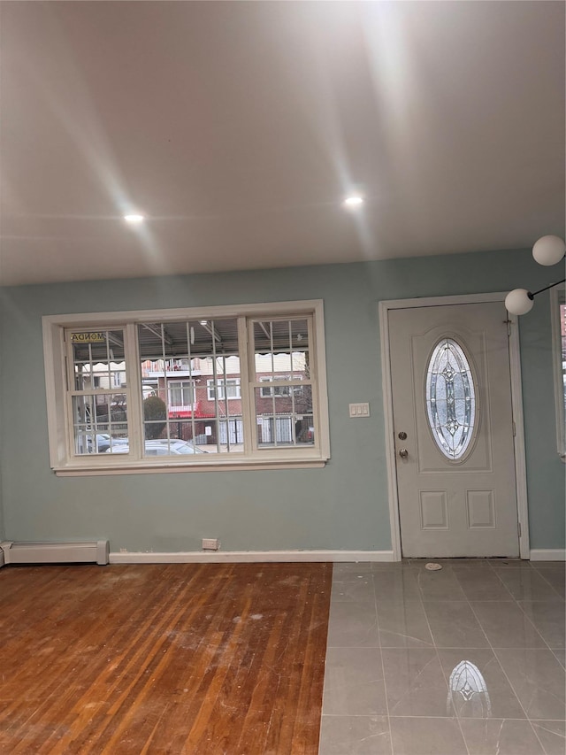 entryway featuring a baseboard radiator, baseboards, and wood finished floors