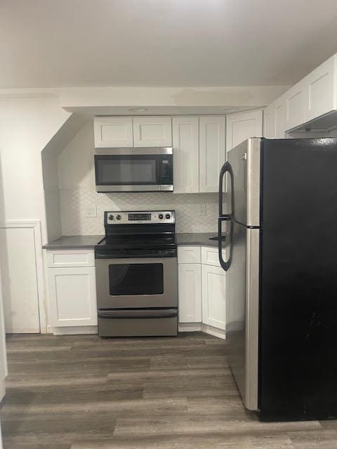 kitchen featuring dark wood finished floors, white cabinets, stainless steel appliances, and tasteful backsplash