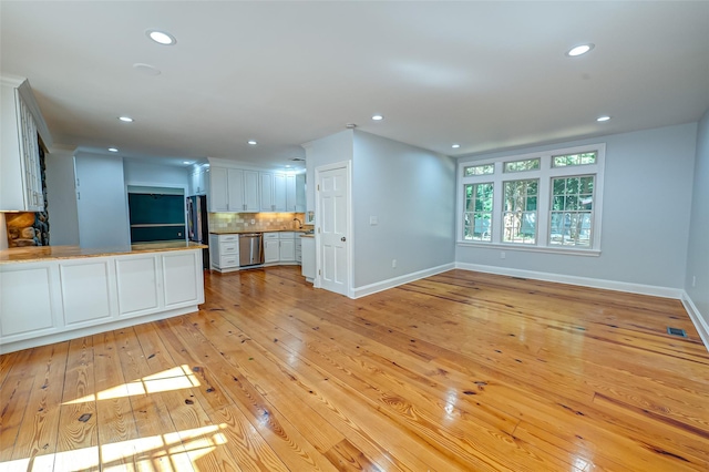 unfurnished living room with light wood-type flooring, visible vents, baseboards, and recessed lighting