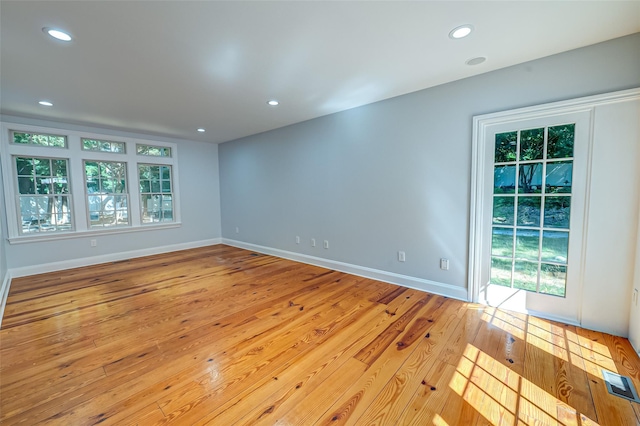 unfurnished room featuring hardwood / wood-style floors, plenty of natural light, and recessed lighting