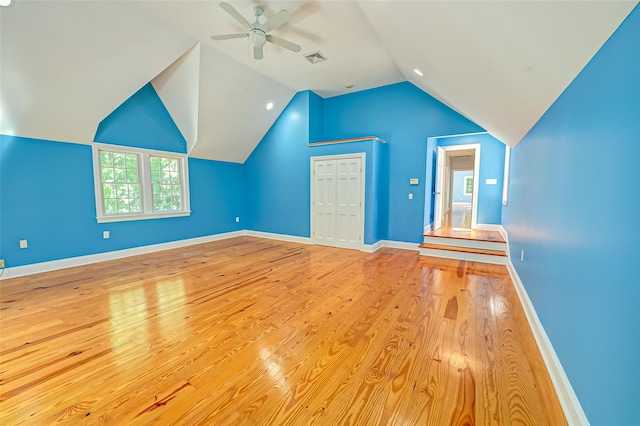 additional living space with lofted ceiling, visible vents, a ceiling fan, wood finished floors, and baseboards