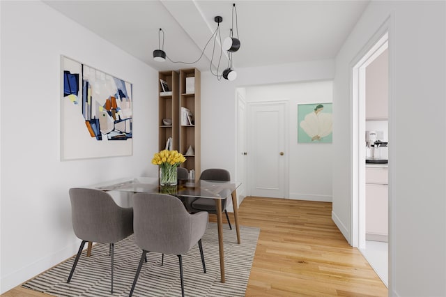 dining space with baseboards and light wood finished floors