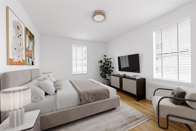 bedroom with radiator and light wood-style floors