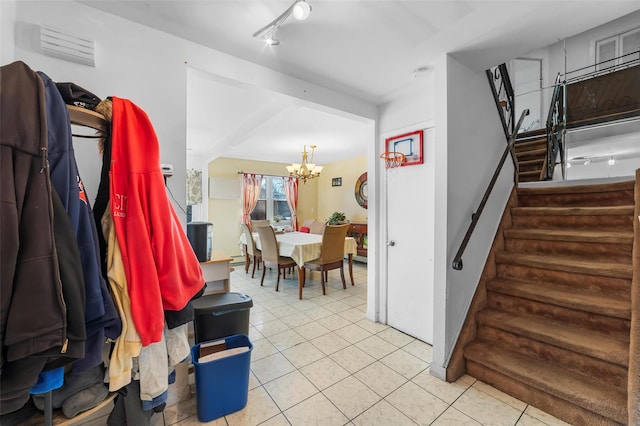 interior space featuring tile patterned flooring, rail lighting, and an inviting chandelier