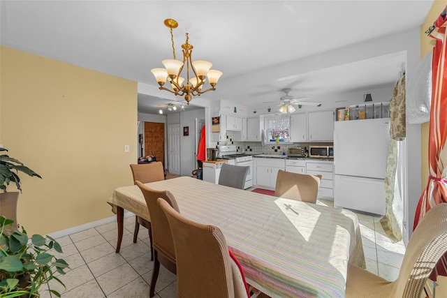 dining area with light tile patterned floors, ceiling fan with notable chandelier, and baseboards