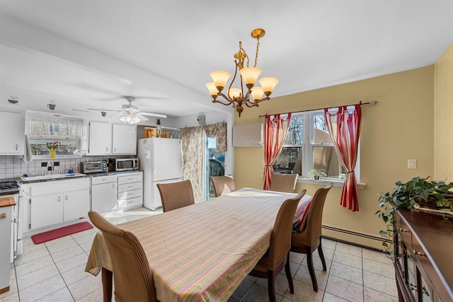 dining room featuring light tile patterned floors, a baseboard radiator, a toaster, and ceiling fan with notable chandelier