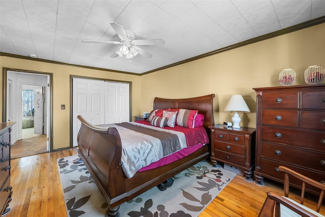 bedroom featuring light wood-style floors, a ceiling fan, ornamental molding, and a closet