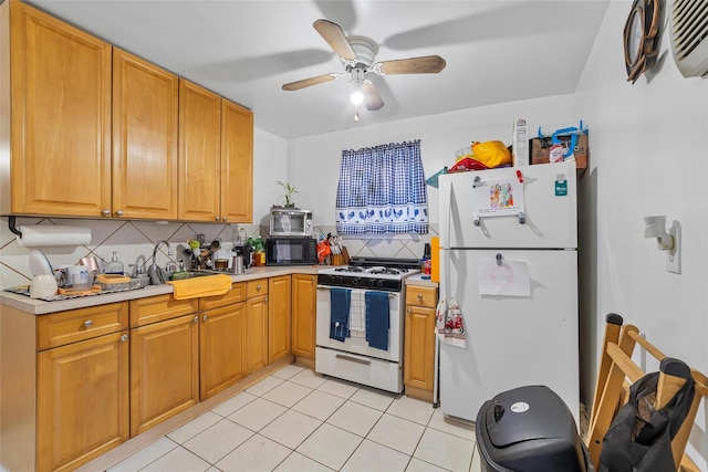 kitchen featuring white appliances, a ceiling fan, light countertops, and backsplash