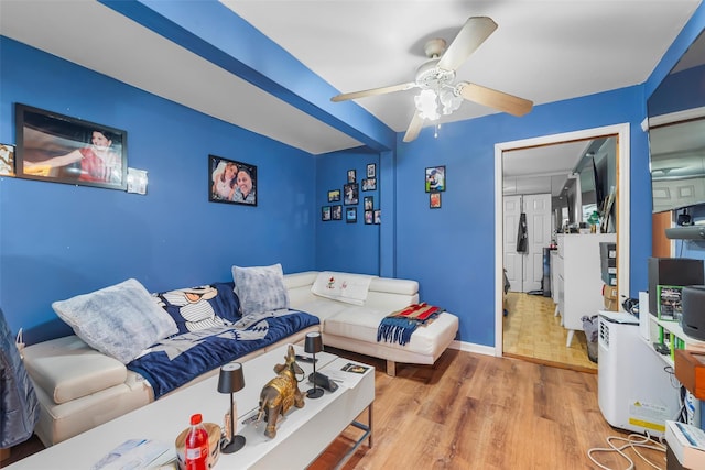 interior space with baseboards, a ceiling fan, and wood finished floors