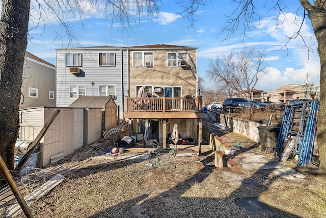 rear view of house featuring an outbuilding, fence, a deck, and a storage shed