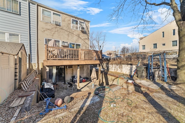 rear view of property with an outbuilding, fence, a wooden deck, a patio area, and a shed