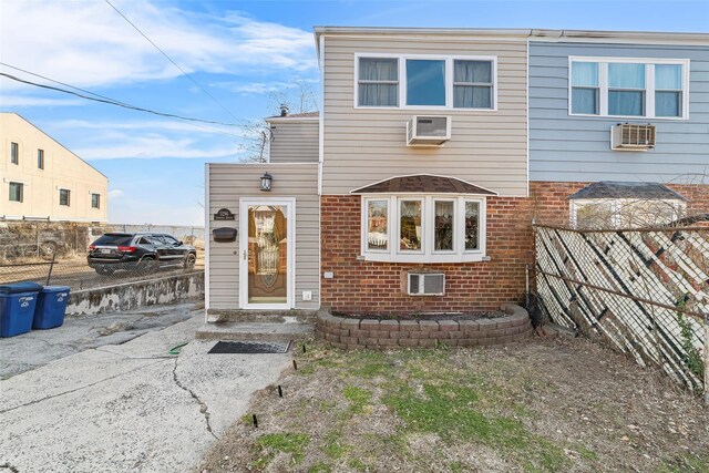 3296 Griswold Ave, Bronx, NY 10465 - view of front of house featuring brick siding, fence, and a wall mounted air conditioner