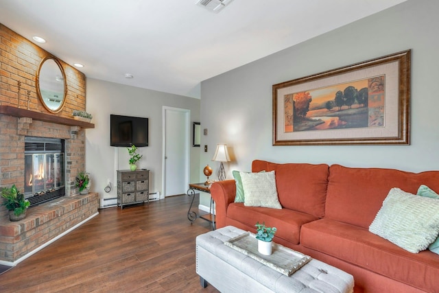 living room featuring visible vents, a fireplace, baseboard heating, and wood finished floors