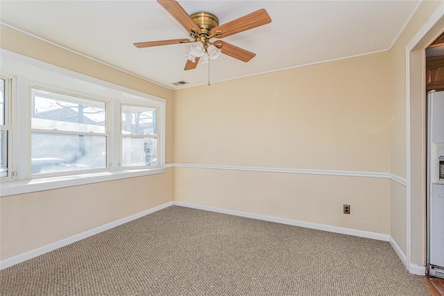 spare room featuring a ceiling fan, carpet flooring, baseboards, and visible vents