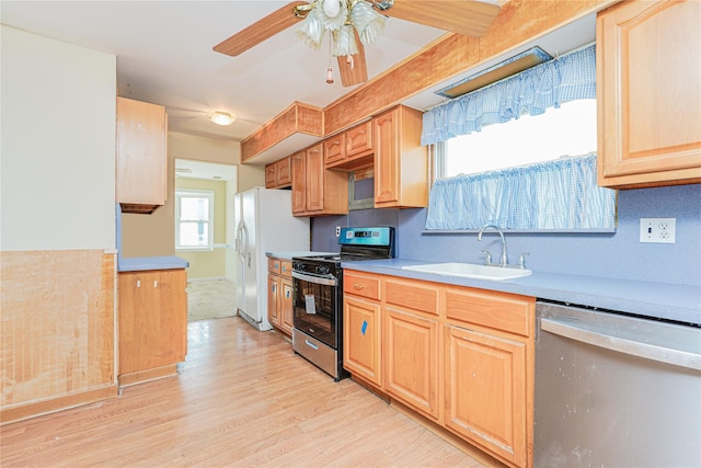 kitchen featuring light wood-style flooring, a sink, light brown cabinetry, light countertops, and stainless steel appliances