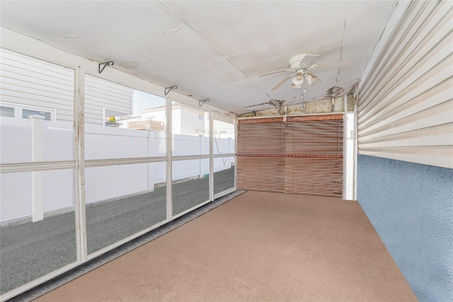 unfurnished sunroom with a ceiling fan