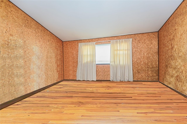 unfurnished room featuring wood finished floors and baseboards