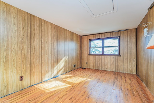 spare room featuring wooden walls and wood-type flooring