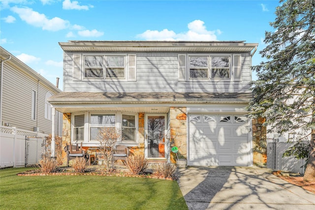 view of front of home featuring fence, a front yard, covered porch, stone siding, and an attached garage