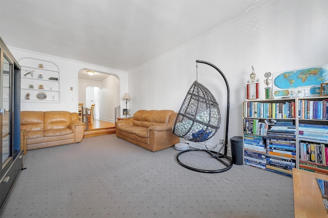 carpeted living area featuring arched walkways and crown molding