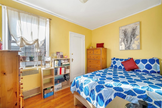 bedroom featuring wood finished floors and ornamental molding