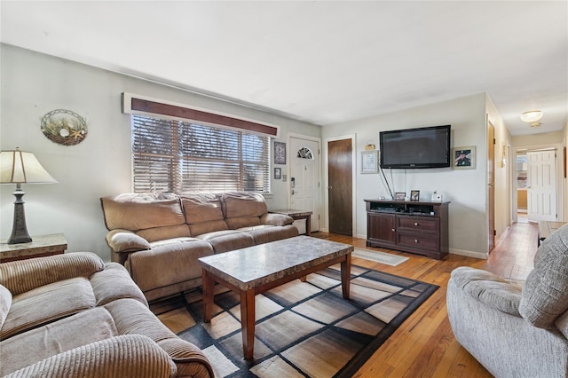 living area with baseboards and light wood finished floors