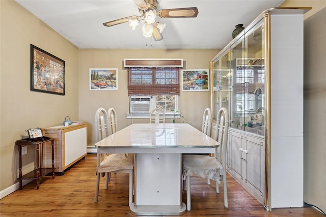 dining room featuring light wood-type flooring, ceiling fan, baseboards, and a baseboard radiator