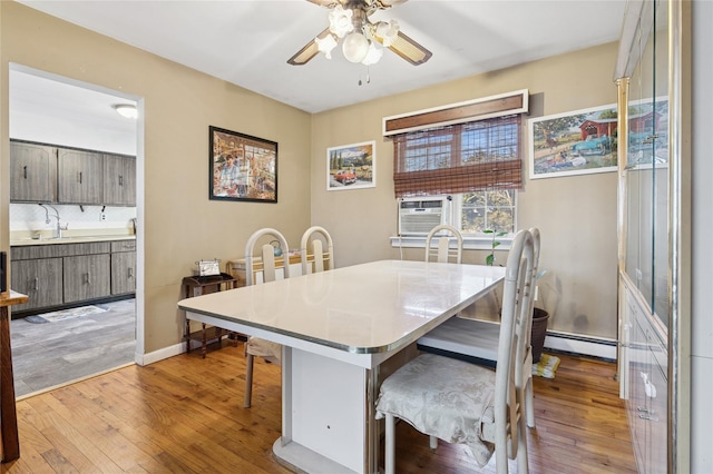 dining area featuring a baseboard radiator, light wood-style floors, ceiling fan, and cooling unit